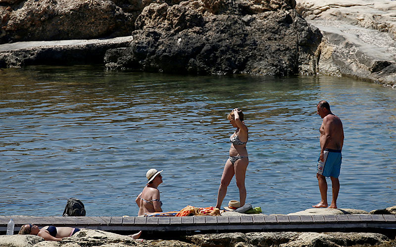 People try to cool off on a rocky beach as a heatwave hits Europe, in Sliema, Malta, on 26 June 2019. Photo: Reuters