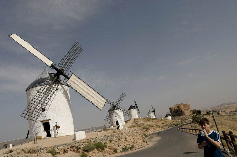 A tourist drinks water as he visits La Mancha windmills during a heatwave in Consuegra, central Spain, 27 June, 2019. Photo: Reuters