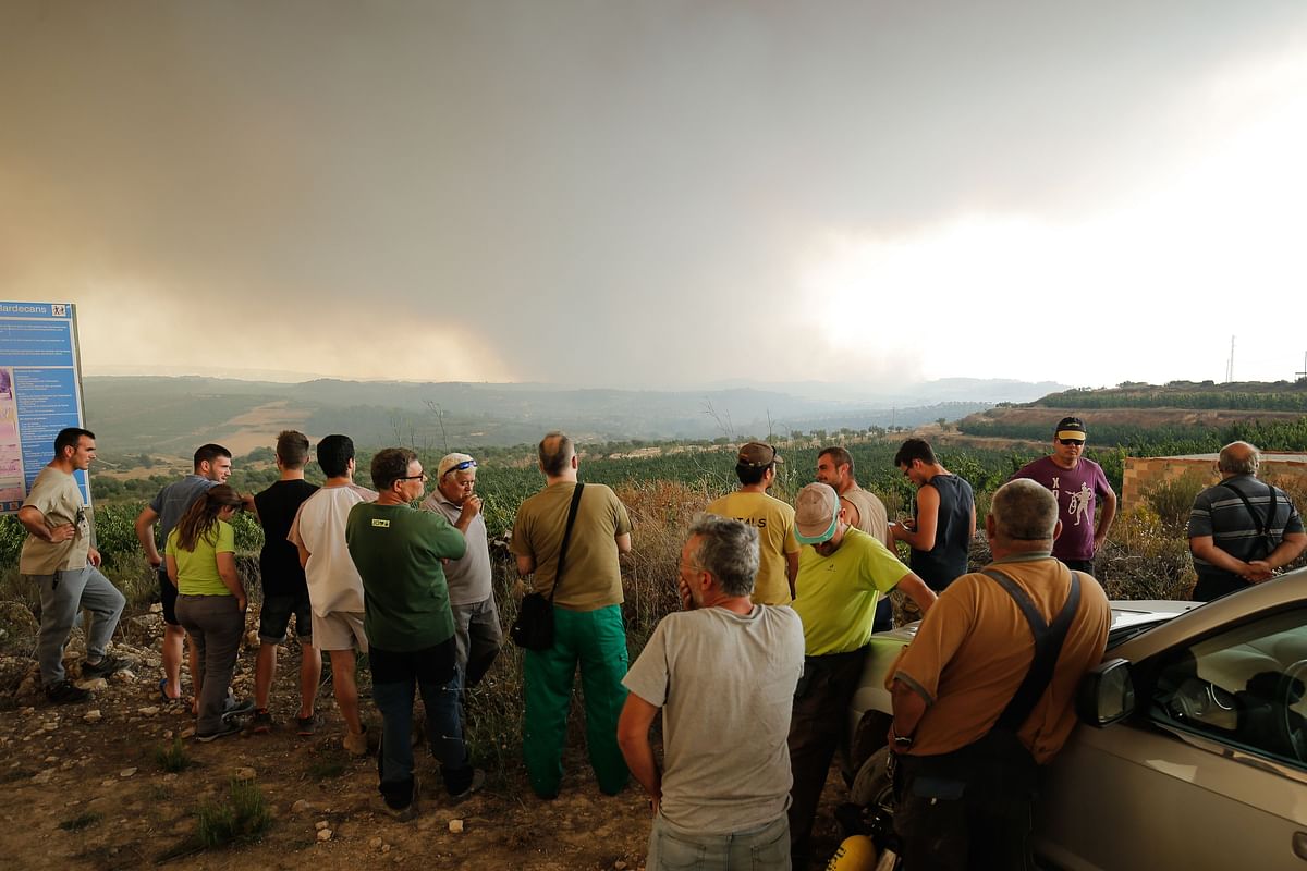 Residents gather to observe a forest fire raging near Maials in the northeastern region of Catalonia on 27 June 2019. Photo: AFP