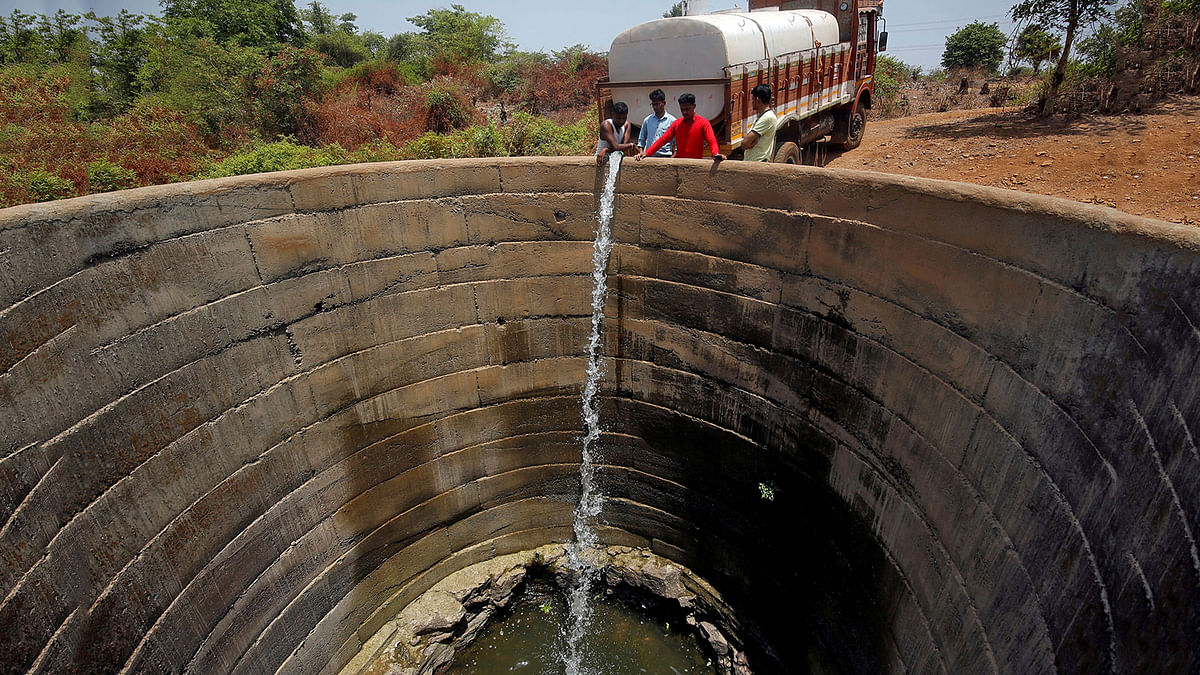 A dried-up well is refilled with water from a water tanker in Thane district in the western state of Maharashtra, India, on 30 May 2019. Reuters File Photo
