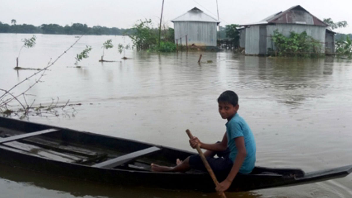A boy rows boat as people are marooned after torrential rain over the last few days in Sylhet. Photo: UNB