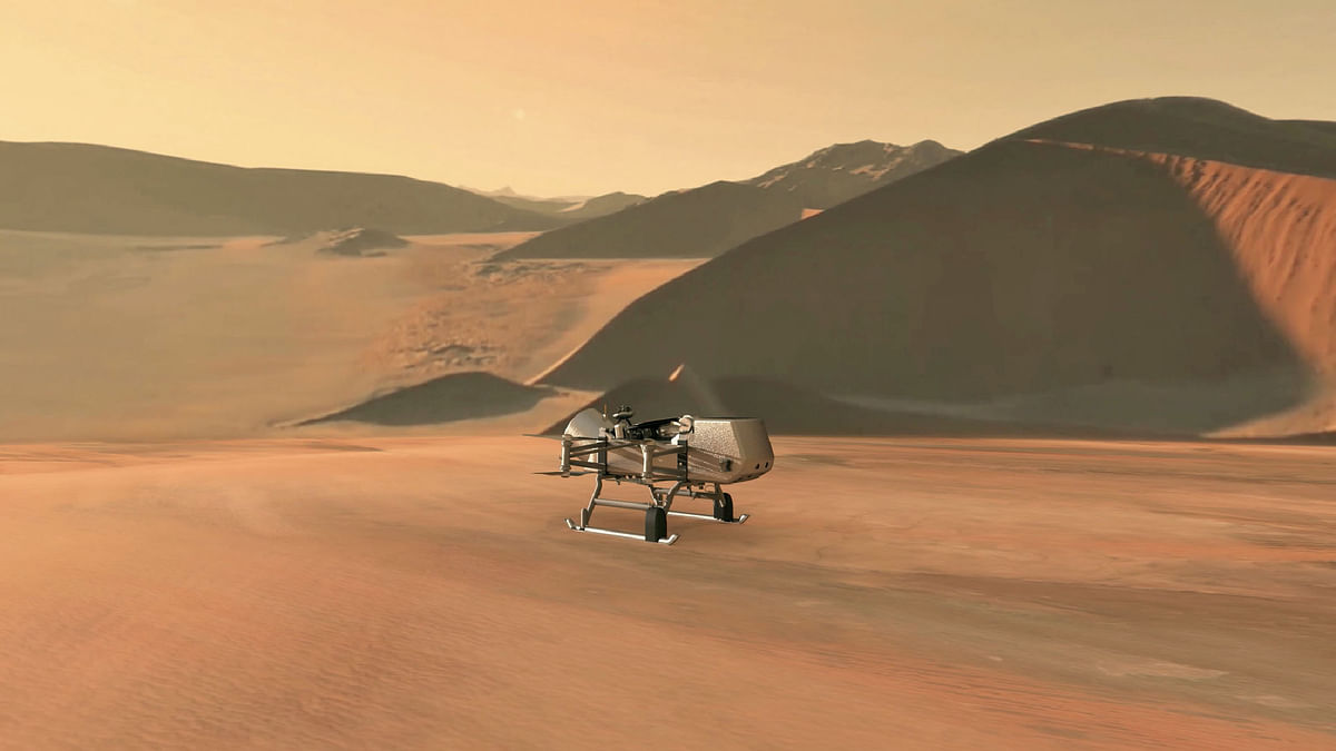 This NASA artist`s illustration released on 27 June 2019 shows NASA’s Dragonfly rotorcraft-lander approaching a site on Saturn’s exotic moon, Titan. Photo: AFP