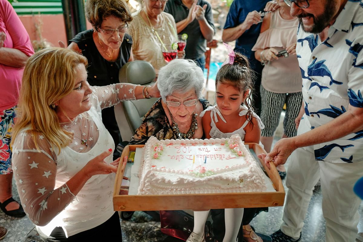 Cuban Delia Barroso, 102, blows out the cake candles during her birthday in Havana, on 18 May 2019. Photo: AFP