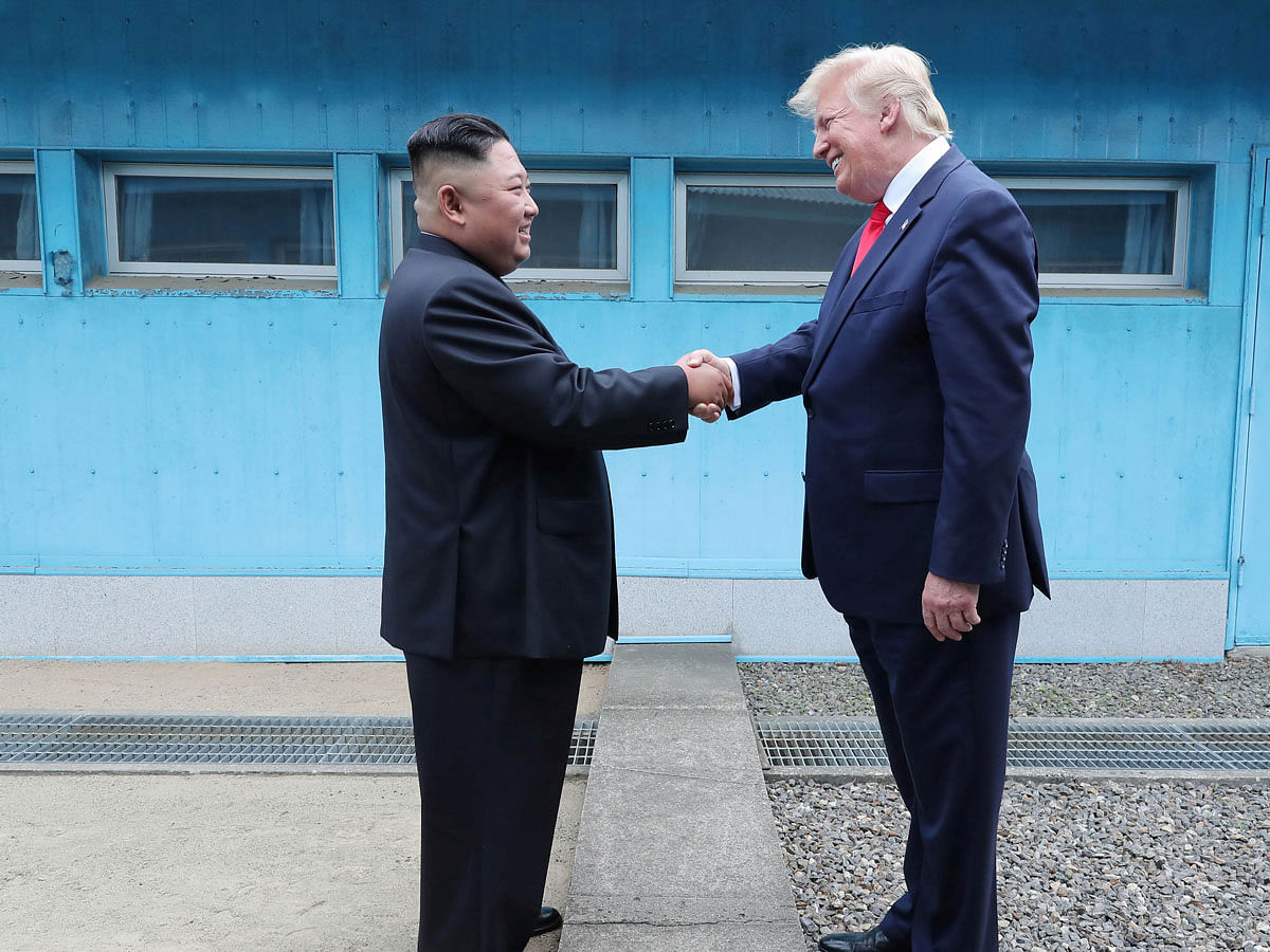 This picture taken on 30 June 2019 and released by North Korea`s official Korean Central News Agency (KCNA) on 1 July 2019 shows North Korea`s leader Kim Jong Un (L) shaking hands with US President Donald Trump at the Military Demarcation Line that divides North and South Korea, in the Joint Security Area (JSA) of Panmunjom in the Demilitarized zone (DMZ). Photo: AFP