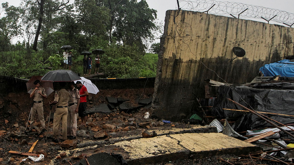Police personnel stand among the debris after a wall collapsed on hutments due to heavy rains in Mumbai, India 2 July, 2019. Photo: Reuters