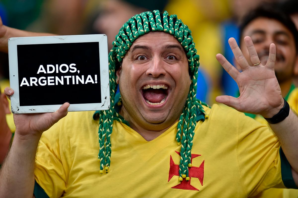 A fan of Brazil holds a board reading `Bye-bye Argentina` as he waits for the start of the Copa America football tournament semi-final match against Argentina at the Mineirao Stadium in Belo Horizonte, Brazil, on July 2, 2019. / AFP