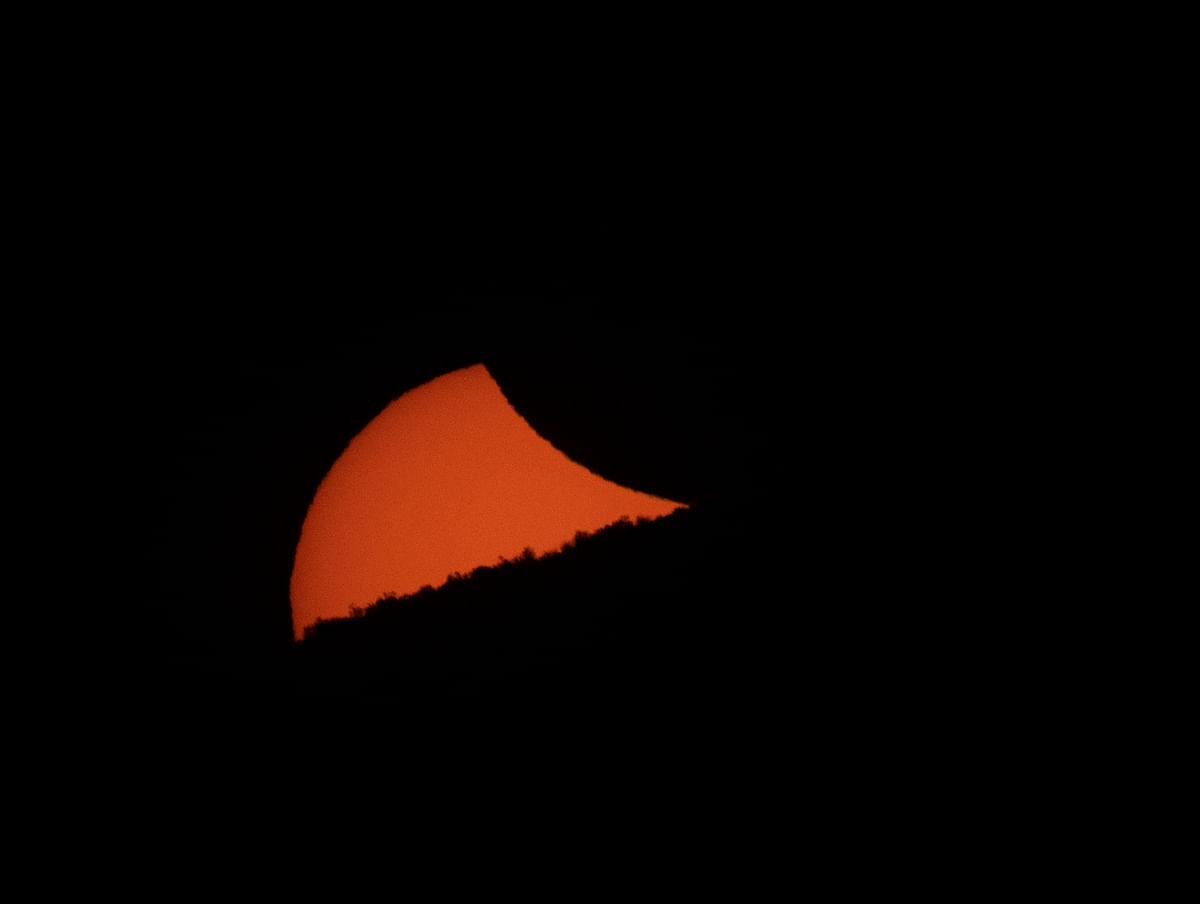 1A partially eclipsed sun sets behind a mountain ridge as seen from El Molle, Chile, on 2 July 2019 after the total solar eclipse. Tens of thousands of tourists braced Tuesday for a rare total solar eclipse that was expected to turn day into night along a large swath of Latin America`s southern cone, including much of Chile and Argentina. Photo: AFP