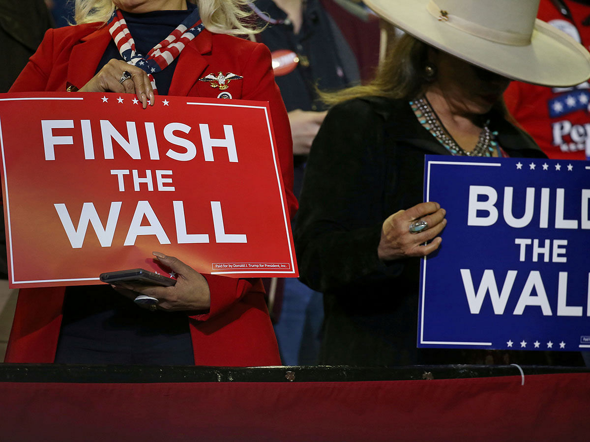 Supporters hold placards as US president Donald Trump holds a rally at El Paso County Coliseum in El Paso, Texas, US, on 11 February 2019. Reuters File Photo