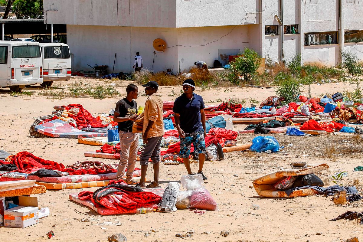 Migrants stand and walk outside at a detention centre used by the Libyan Government of National Accord (GNA) in the capital Tripoli`s southern suburb of Tajoura on 3 July 2019, following an air strike on a nearby building that left dozens killed the previous night. Photo: AFP