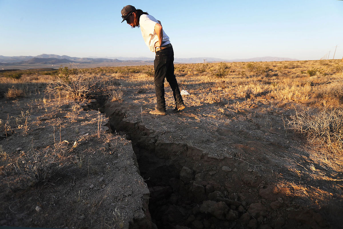 A local resident inspects a crack in the earth after a 6.4 magnitude earthquake struck the area on 4 July 2019 near Ridgecrest, California. Photo: AFP