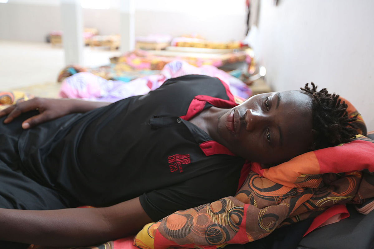 A Malian migrant Souleyman Coulibaly, who was rescued after the boat capsized in the Mediterranean Sea off the Tunisian Coast on its way from Libya to Italy, lies on a bed at the Red Crescent centre in the Tunisian coastal city of Zarzis on 4 July 2019. Photo: AFP