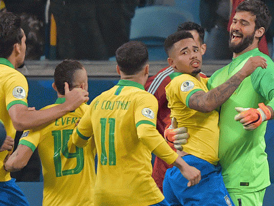 Brazil’s Gabriel Jesus (2-R) celebrates with goalkeeper Alisson (R) and teammates after scoring his penalty to defeat Paraguay in the penalty shoot-out after tying 0-0 during their Copa America football tournament quarter-final match at the Gremio Arena in Porto Alegre, Brazil, on 27 June 2019. Photo: AFP