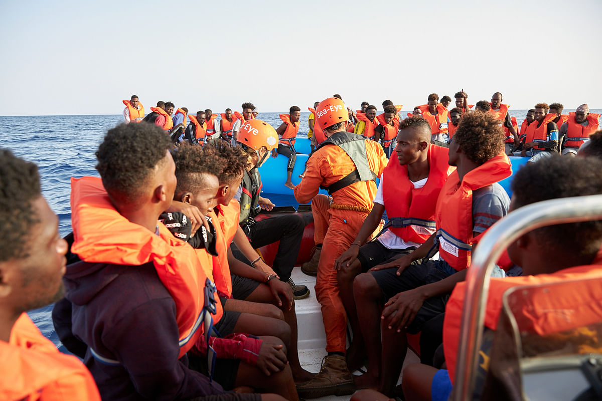 Migrants are evacuated from a blue inflatable boat by the crew of a rescue vessel Alan Kurdi about 34 miles from the Libyan coast according to Sea-eye, in this picture obtained from social media on 5 July. Photo: Reuters