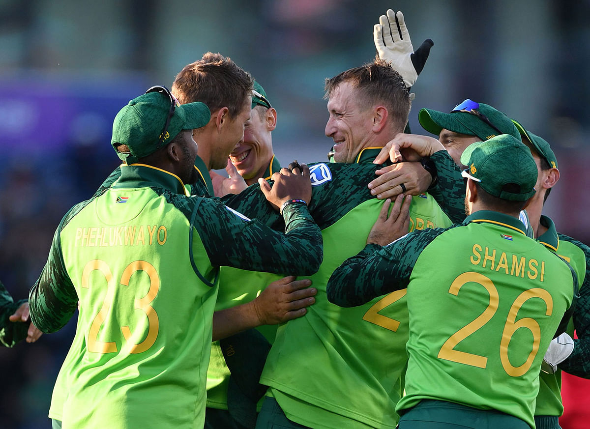 South Africa`s Chris Morris (C) celebrates with teammates after taking a catch to dismiss Australia`s David Warner during the 2019 Cricket World Cup group stage match between Australia and South Africa at Old Trafford in Manchester, northwest England, on 6 July 2019. Photo: AFP