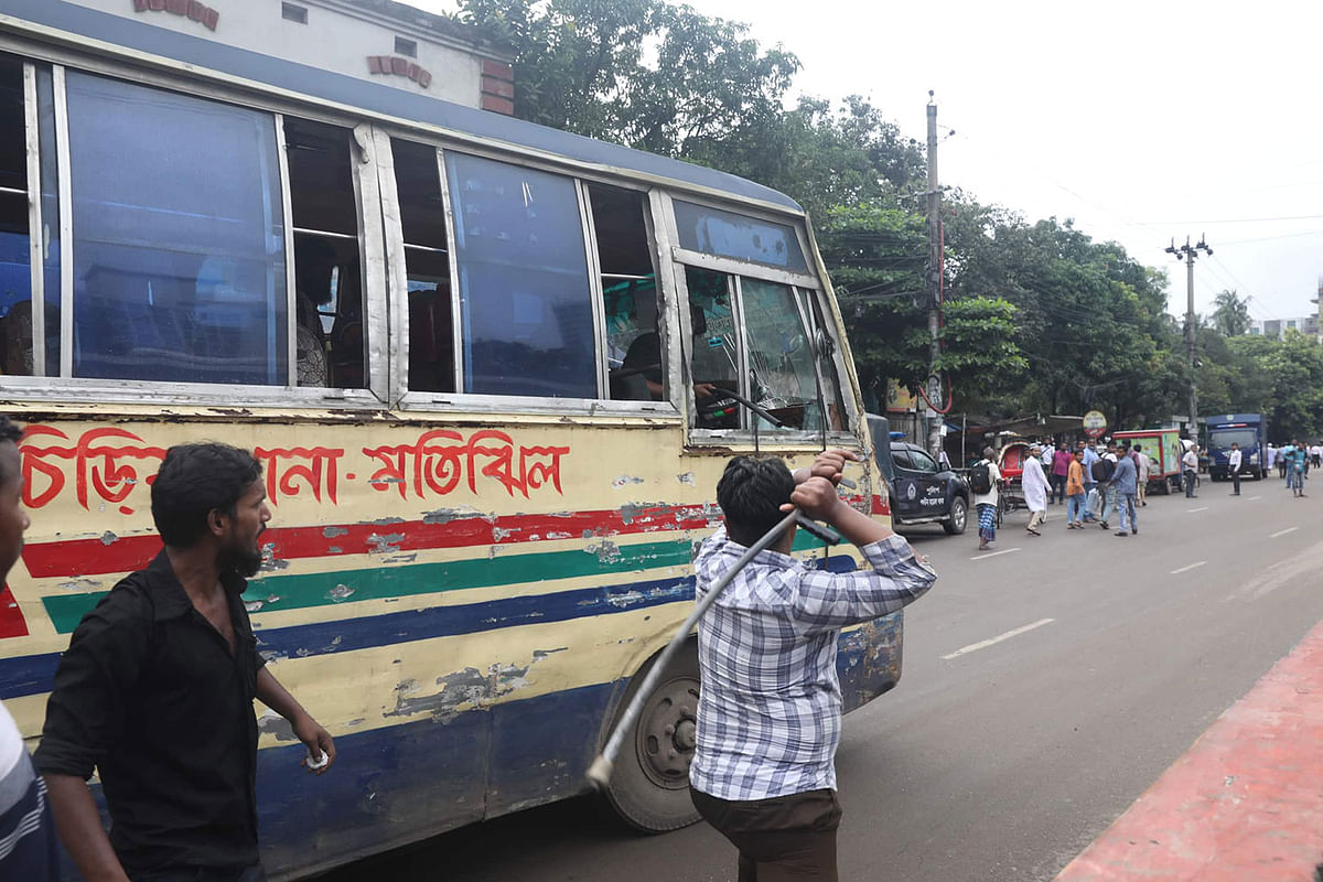 A protester attempts to vandalise a bus during the hartal against the recent gas price hike. Paltan, Dhaka on 7 July 2019. Photo: Saiful Islam