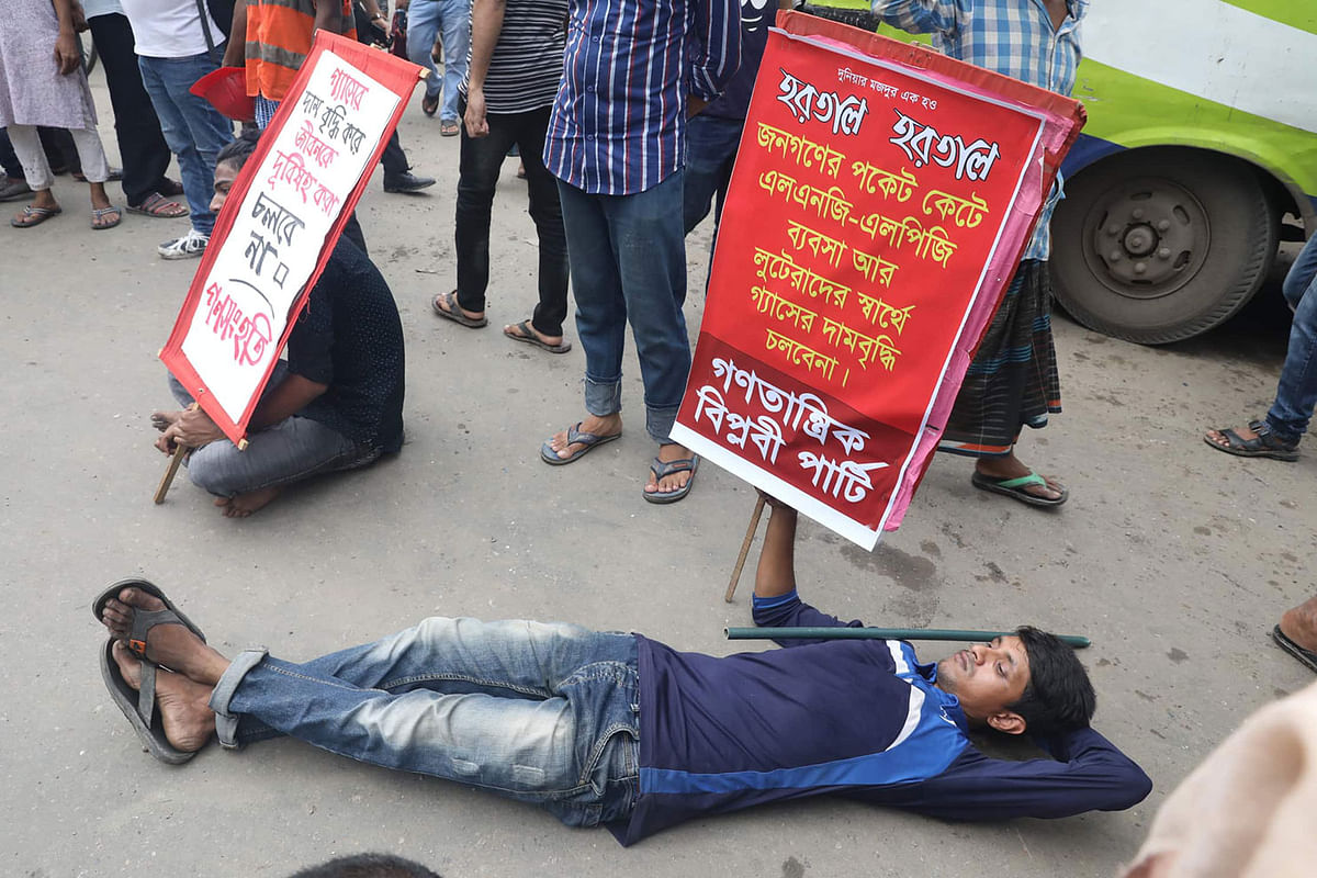 Two protesters lie on the road during a demonstration protesting against the recent gas price hike. This photo is taken from Paltan in the capital on 7 July 2019. Photo: Saiful Islam