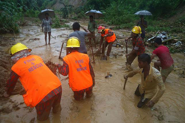Bangladeshi fire fighters and residents search for bodies after a landslide in Bandarban on 13 July 2017. Heavy monsoon rains have killed at least 46 people in southeast Bangladesh, most of them buried under landslides, authorities said on 13 July. Photo: AFP