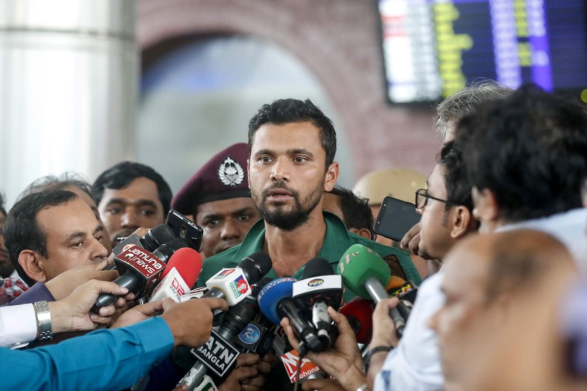 Bangladeshi cricket captain Mashrafe Bin Mortaza (C) talks to journalists upon his arrival with his teammates at Hazrat Shahjalal International Airport in Dhaka on July 7, 2019, after leaving the 2019 cricket World Cup. Bangladesh captain Mashrafe Mortaza on July 7 said he regretted his team let down its supporters and that he took responsibility for failing to reach the World Cup final four. AFP
