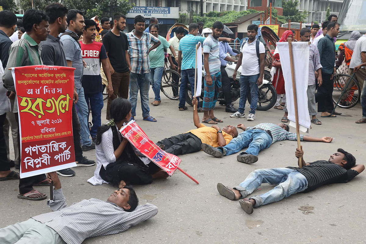 A number of protesters lie on the road during a demonstration protesting against the recent gas price hike. This photo is taken from Paltan in the capital on 7 July 2019. Photo: Saiful Islam