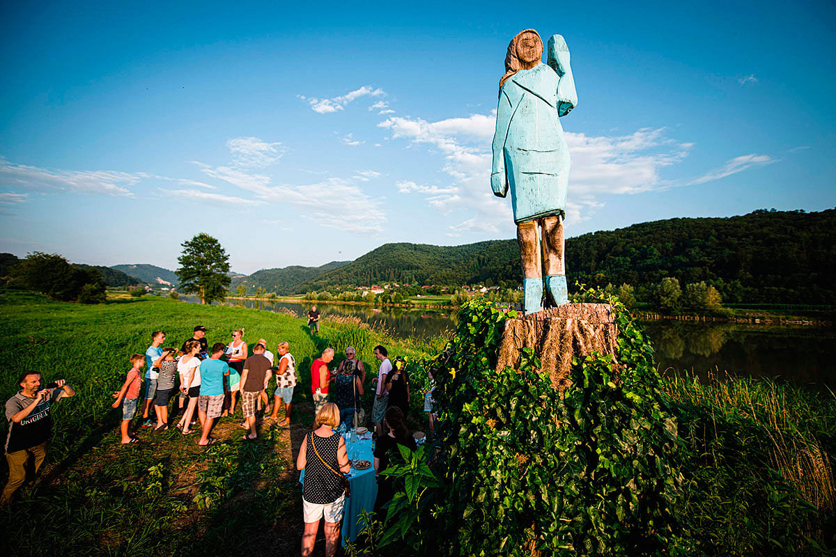 People gather around what conceptual artist Ales `Maxi` Zupevc claims is the first ever monument of Melania Trump, set in the fields near the town of Sevnica, US First Lady’s hometown, during a small inauguration celebration on 5 July 2019. Photo: AFP