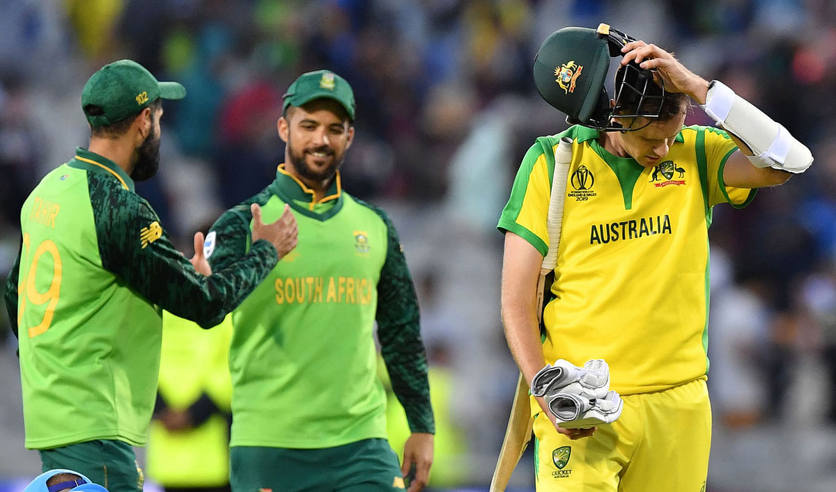 Australia`s Jason Behrendorff (R) walks off the field as South Africa`s Imran Tahir (L) and South Africa`s JP Duminy (2L) embrace after the 2019 Cricket World Cup group stage match between Australia and South Africa at Old Trafford in Manchester, northwest England, on 6 July 2019. Photo: AFP