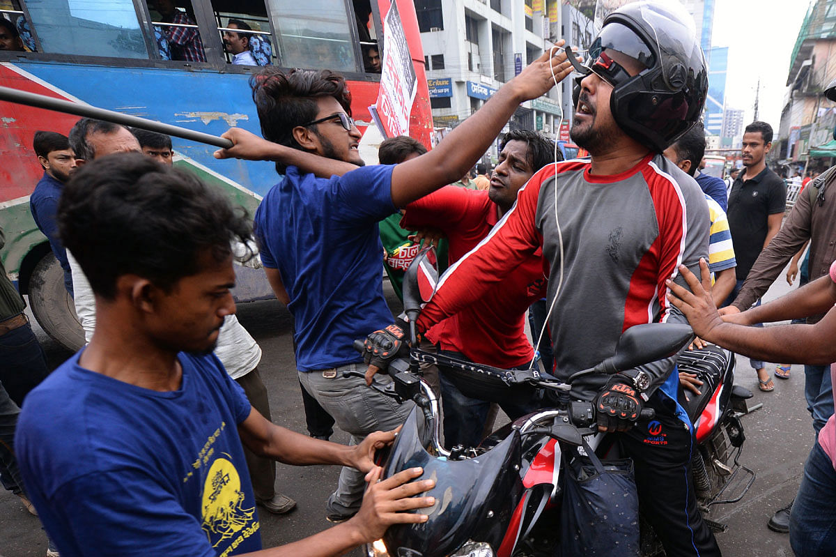 Activists scuffle with commuters as they block a road during a half-day strike in Dhaka on 7 July 2019, protesting the Bangladeshi government’s decision to hike gas prices. Photo: AFP