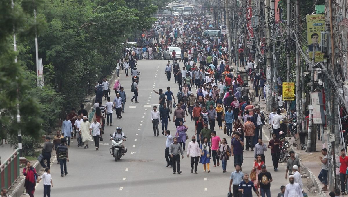 People are forced to walk as rickshaw-pullers block road protesting the decision banning the plying of rickshaws on three major thoroughfares of the capital on Tuesday morning. Photo: UNB