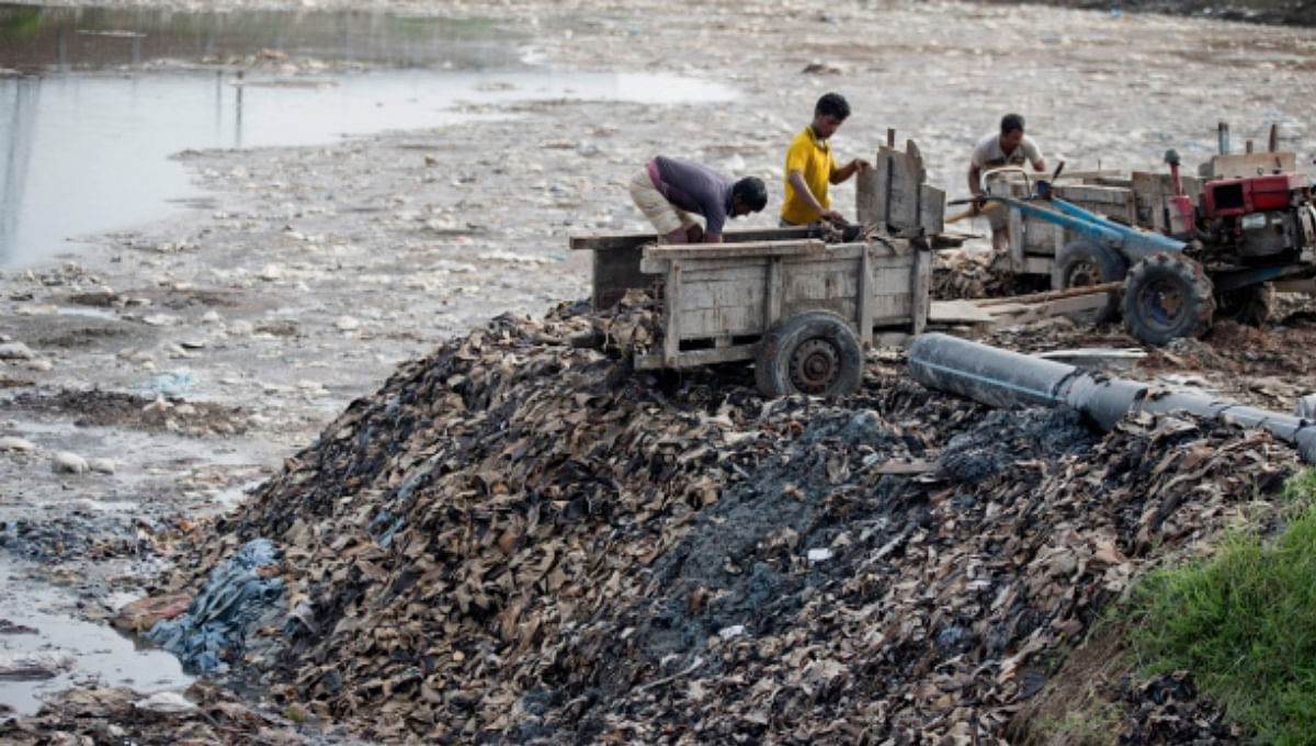 Labourers work to dump tannery wastages. Photo: UNB