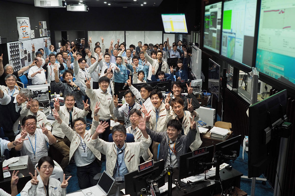 This handout photograph taken and released by the Institute of Space and Astronautical Science (ISAS) of Japan Aerospace Exploration Agency (JAXA) on 11 July 2019 shows researchers and employees celebrating after receiving confirmation of Hayabusa2`s touchdown on the asteroid Ryugu, at the mission control room in Sagamihara city, Kanagawa prefecture. Photo: AFP