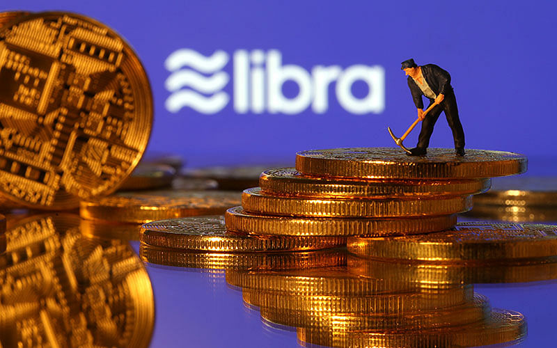A small toy figure stands on representations of virtual currency in front of the Libra logo in this illustration picture on 21 June 2019. Photo: Reuters