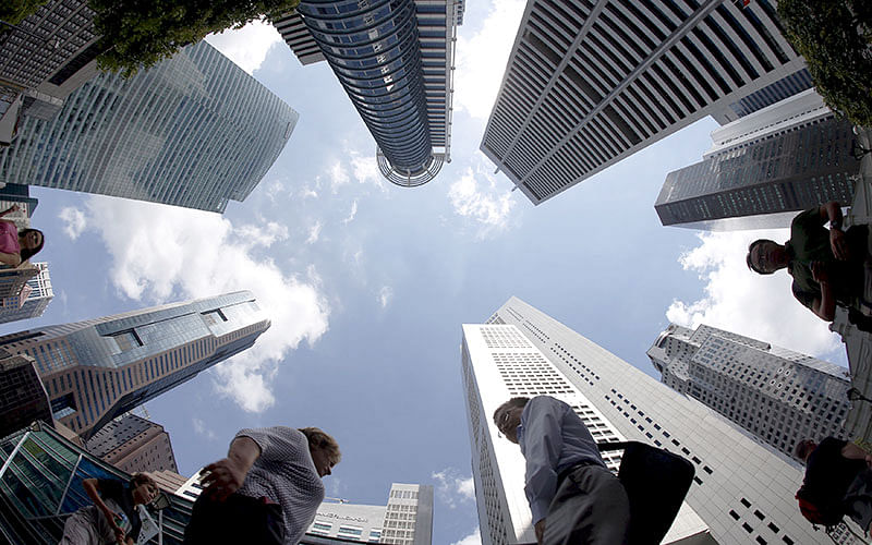 People walk past office buildings at the central business district in Singapore in this 14 April 2015 photo. Reuters File Photo
