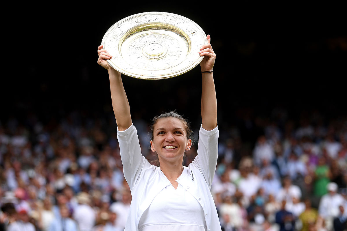 Romania`s Simona Halep poses with the trophy as she celebrates after winning the final against Serena Williams of the US on 13 July, 2019. Photo: Reuters