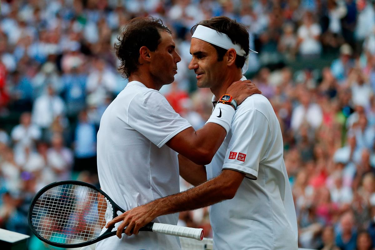 Switzerland`s Roger Federer (R) shakes hands and embraces Spain`s Rafael Nadal (L) after Federer won their men`s singles semi-final match on day 11 of the 2019 Wimbledon Championships at The All England Lawn Tennis Club in Wimbledon, southwest London, on 12 July 2019. Photo: AFP