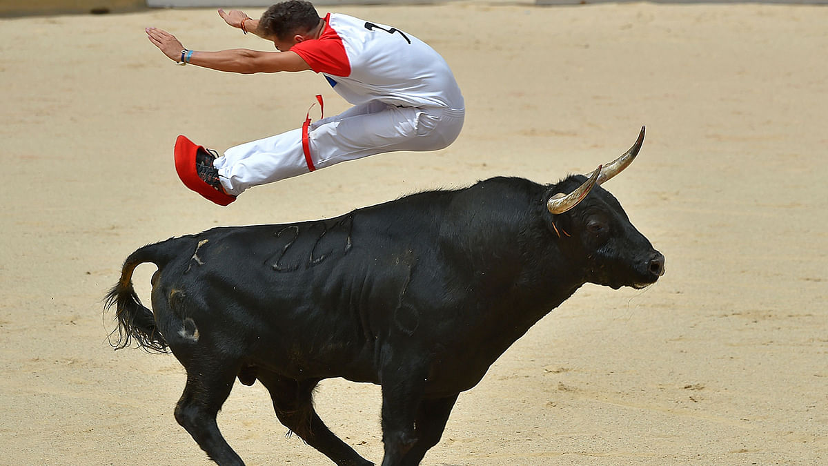 An acrobat jumps over a bull during a bull-leaping show at the San Fermin festival in Pamplona, northern Spain, on 12 July, 2019. People from around the world flock to the city of 200,000 residents to test their bravery and enjoy the festival`s mix of round-the-clock parties, religious processions and concerts. Photo: AFP