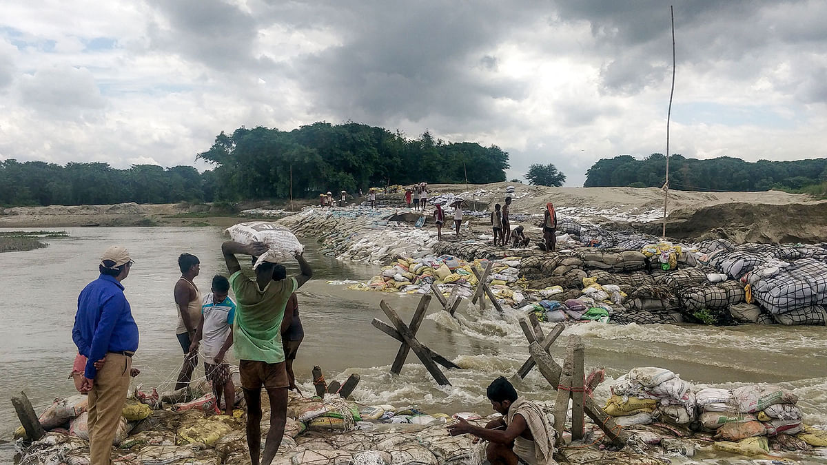Locals gather concrete fragments and heavy bags wrapped in nets to build a dam as floodwaters flow from the north into the state of Indian eastern state of Bihar near Muzaffarpur on13  July, 2019. Floods and landslides triggered by torrential monsoon rains have killed at least 40 people across South Asia in the last two days, officials said. Photo: AFP