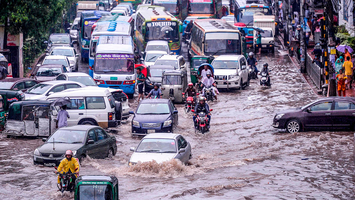 Bangladeshi drivers make their way through heavy rainfall at a water-logged street during the monsoon season in Dhaka on 12 July 2019. Photo: AFP