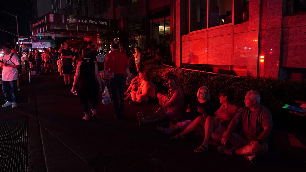 People are seen on the streets in Times Square in the dark during a major power outage affecting parts of New York City on13 July. Photo: Reuters