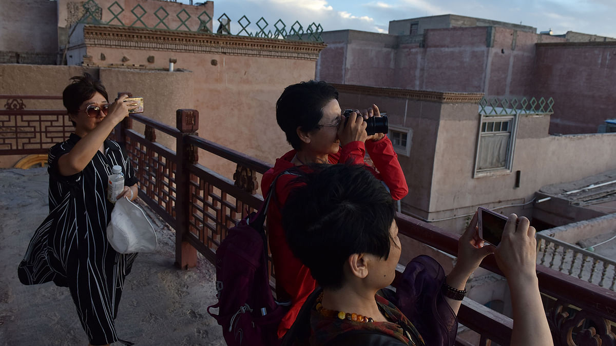 This photo taken on 3 June, 2019 shows tourists taking photos in the restored old city area of Kashgar, in China`s western Xinjiang region. Photo: AFP