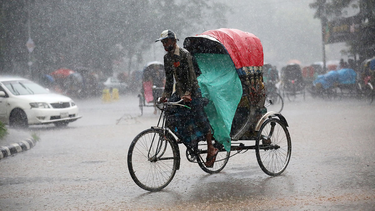 A man rides a rickshaw during heavy rain in Dhaka, Bangladesh, 13 July, 2019. Photo: Reuters