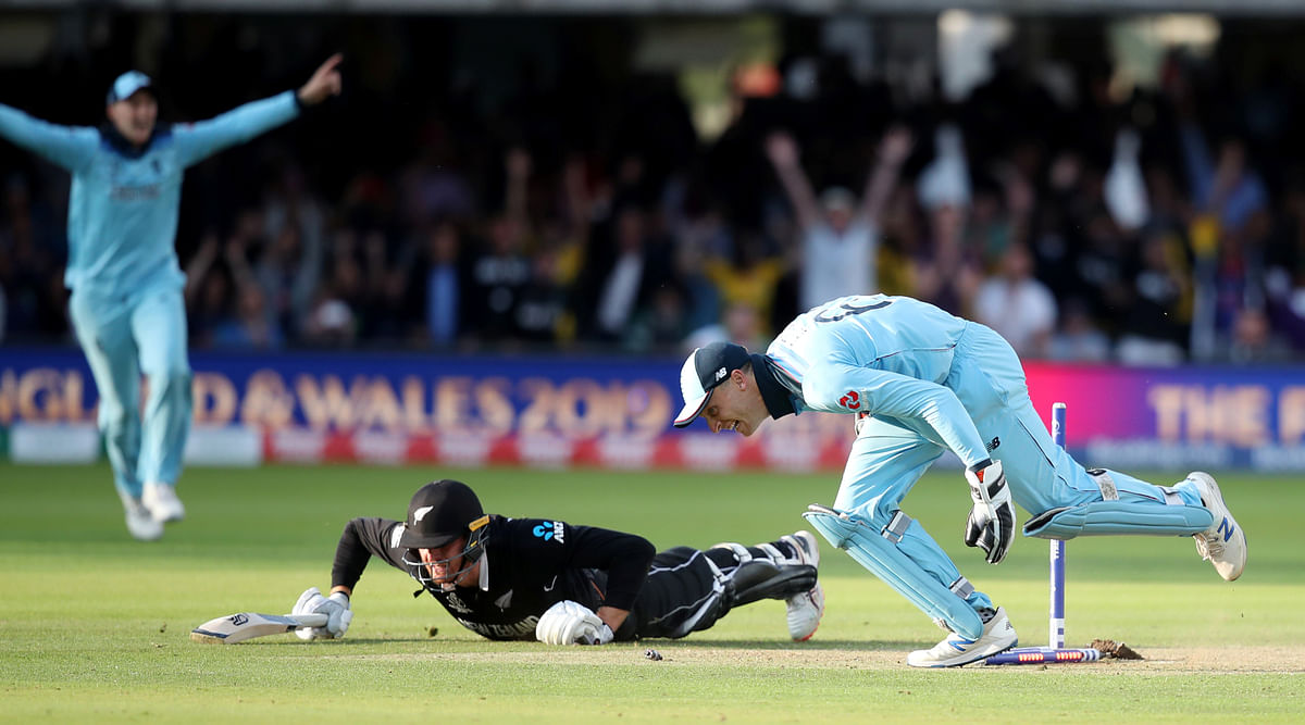 Jos Buttler runs out New Zealand`s Martin Guptill during the super over to win the World Cup. Photo: Reuters