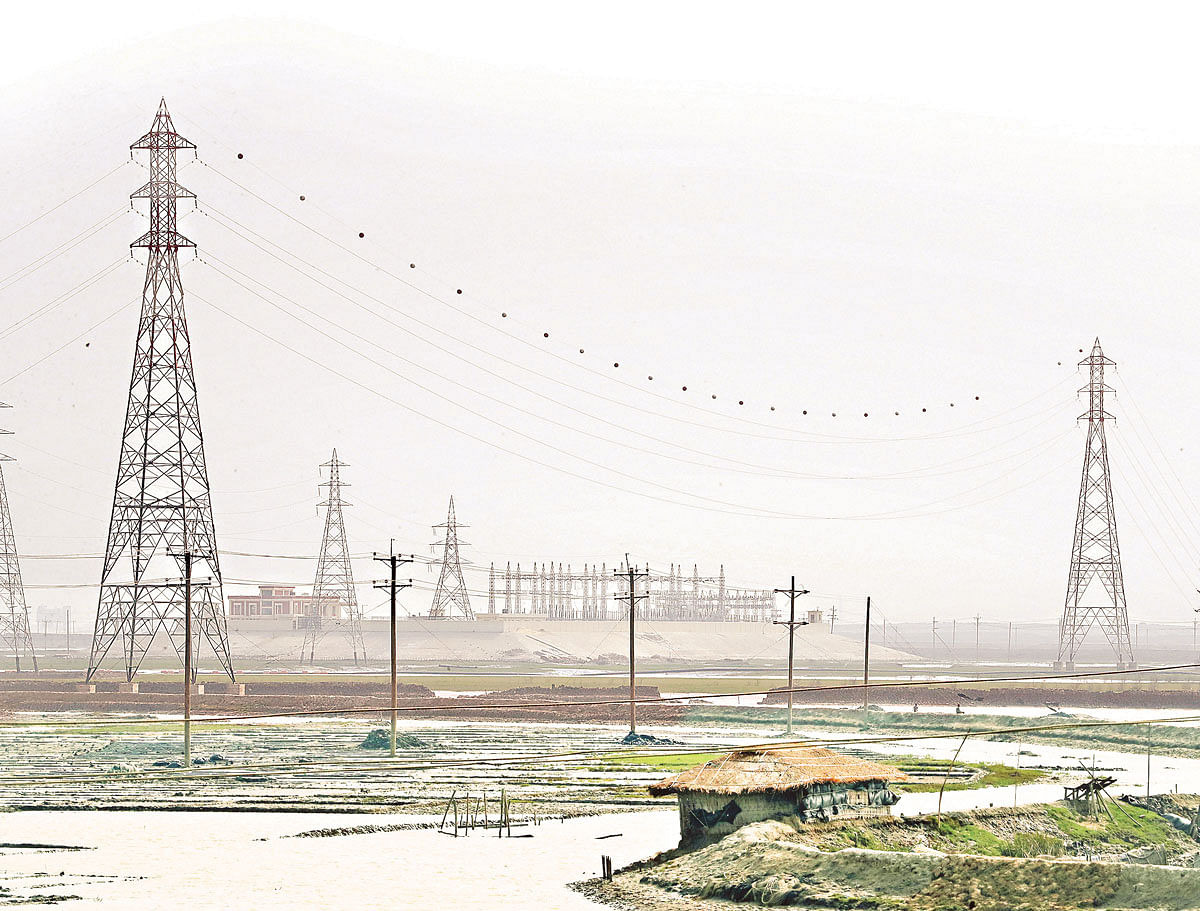 Poles of electricity transmission lines are being installed on salt-producing lands in Matarbari. Photo: Prothom Alo