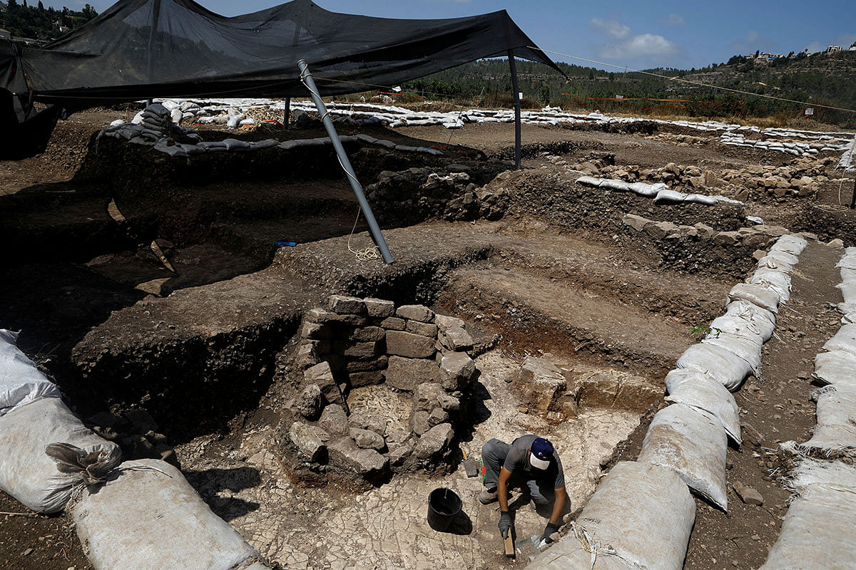 A man works next to a burial place at an excavation site where a huge prehistoric settlement was discovered by Israeli archaeologists in the town of Motza near Jerusalem on 16 July 2019. Photo: Reuters