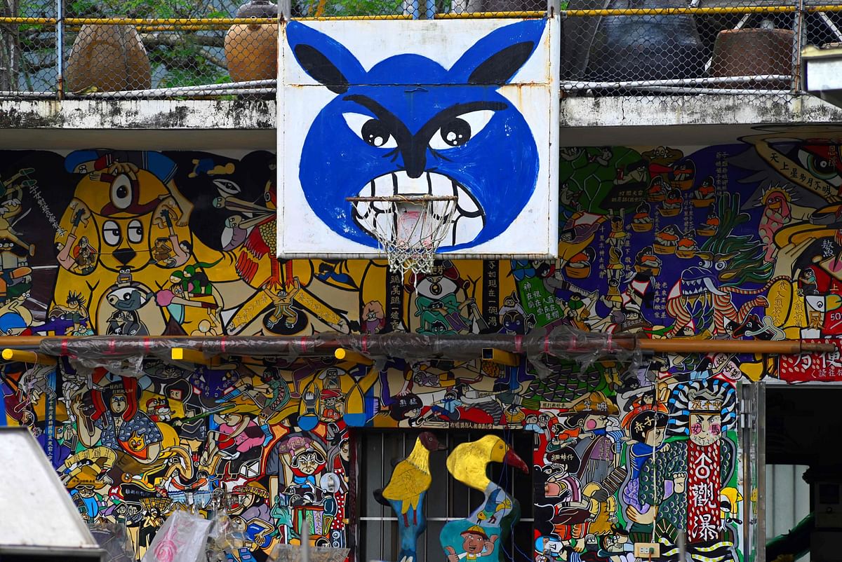 This picture taken on 30 March 2019 shows a basketball hoop and backboard in front of a wall painted by Hakka graffiti artist Wu Tsun-hsien in the Taiwanese village of Ruan Chiao. Photo: AFP