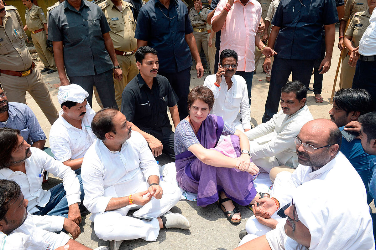 In this handout photo taken and released by the All India Congress Committee (AICC) Communication Department on 19 July 2019, Indian politician Priyanka Gandhi Vadra (C) participates ia a sitting in protest at Narayanpur District, Mirzapur, after being stopped to meet the victims of a shooting which took place over disputed patch of farmland in the northern Indian state of Uttar Pradesh. Photo: AFP