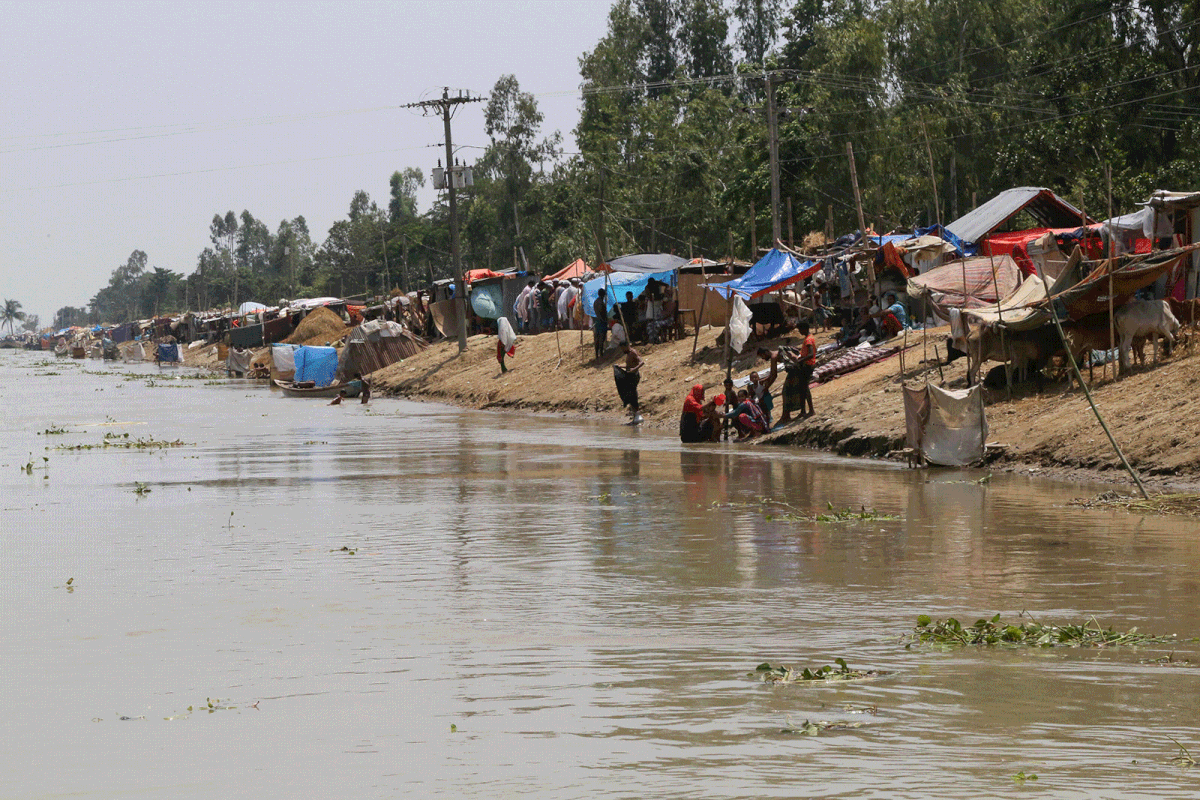 People are seen next to temporary shelters on the embankment of the river Brahmaputra in the flooded area in Gaibandha, Bangladesh, 19 July, 2019. Photo: Reuters