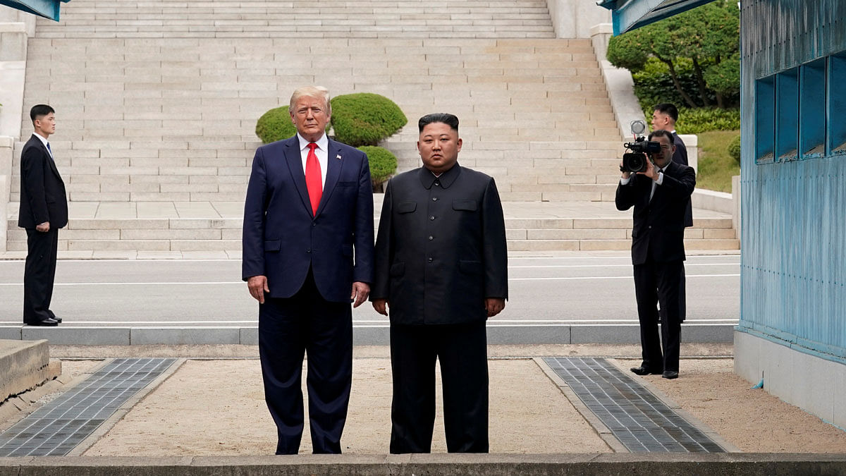 US president Donald Trump and North Korean leader Kim Jong Un stand at the demarcation line in the demilitarised zone separating the two Koreas, in Panmunjom, South Korea, on 30 June 2019. Reuters File Photo