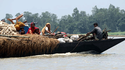 Flood affected people with their household travel on boat to move towards a safe place in Koiyagari village of Dhunat upazila, Bogura on 20 July, 2019. Photo: Soyel Rana