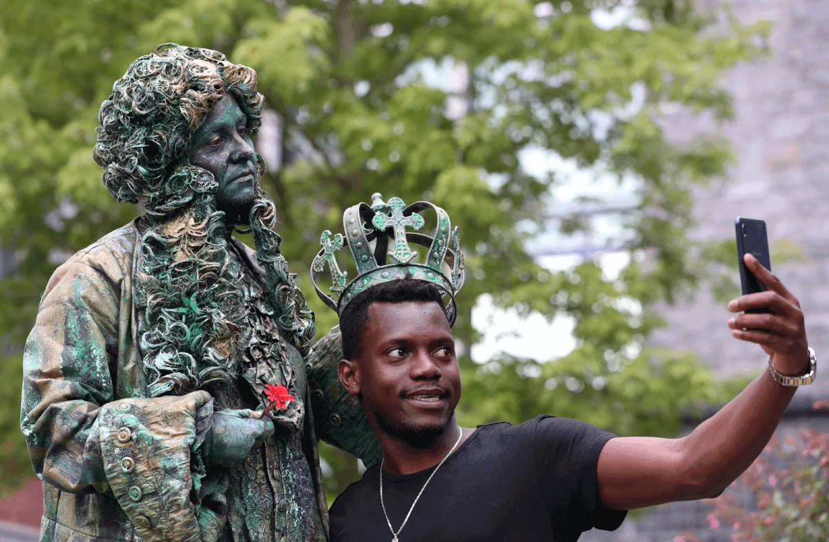 A man takes a selfie with an artist called `The King` who is taking part in the festival `Statues en Marche` in Marche-en-Famenne, Belgium, on 20 July 2019. Photo: Reuters