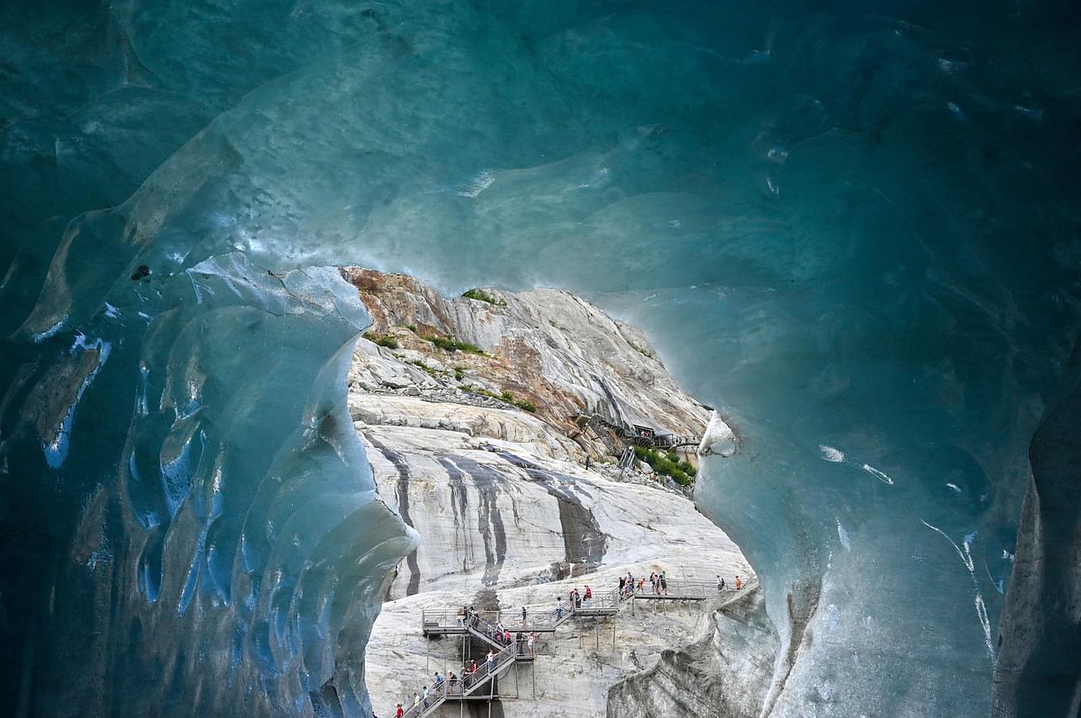 People walk on footbridges as they visit `La Grotte de Glace` (Ice cave) on 19 July 2019 on the largest French glacier, `Mer de Glace` (Sea of Ice), in Chamonix-Mont-Blanc, in the French Alps, eastern France. Photo: AFP