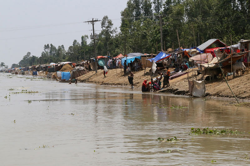 People are seen next to temporary shelters on the embankment of the river Brahmaputra in the flooded area in Gaibandha, Bangladesh, on 19 July 2019. Photo: Reuters